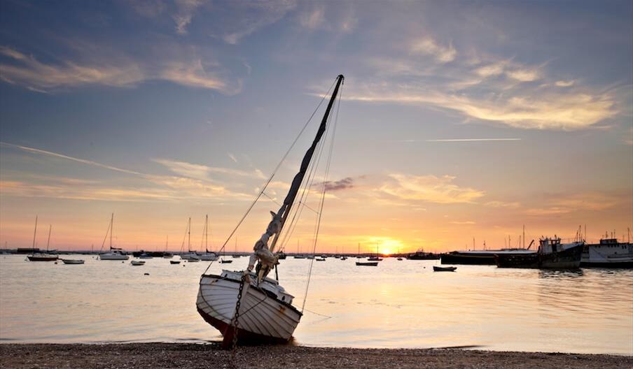 A boat by the seafront on Mersea at sunset